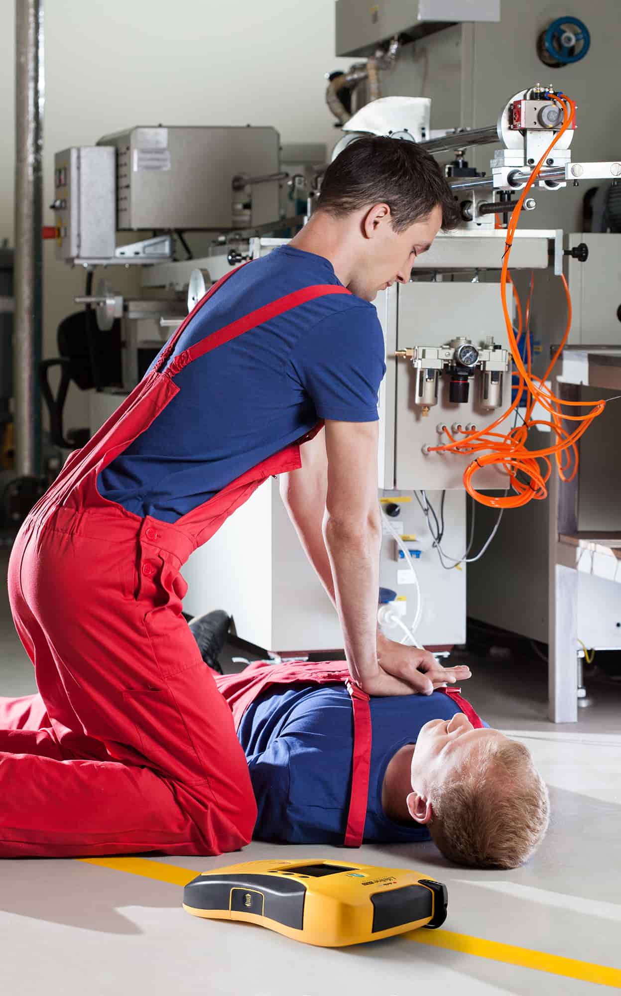 Person placing an AED into a wall cabinet