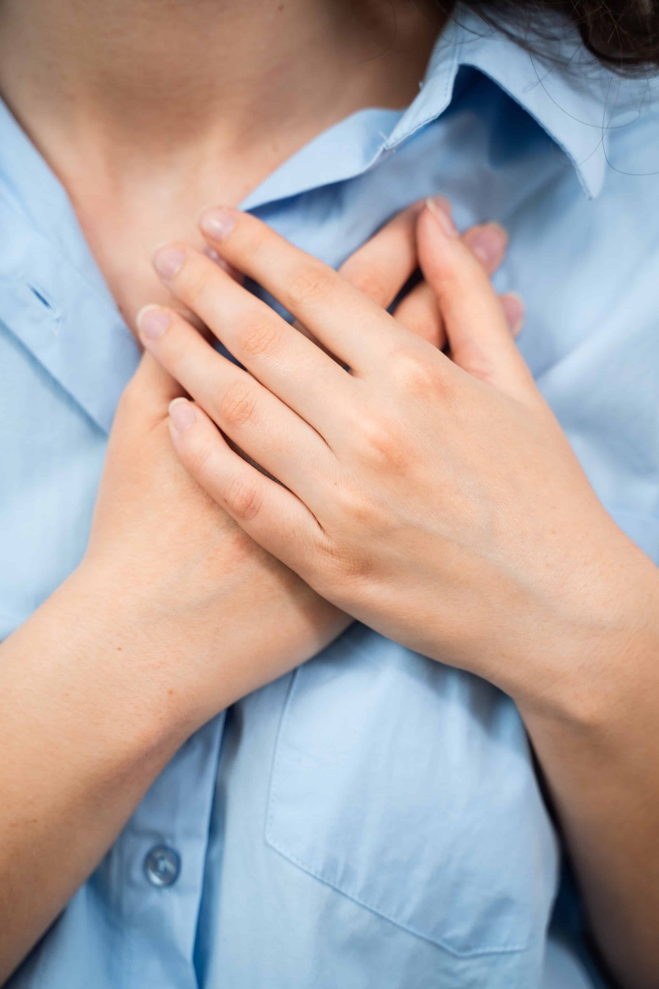 Woman holding her hands over her chest